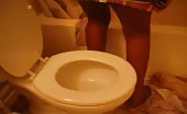 Sexy black girl pooping over the toilet