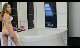 Blonde Woman Pisses in the Bath with a Pink Cup